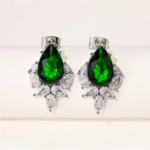 Macro shot of silver stud earrings featuring teardrop green zircon and cluster marquise stones