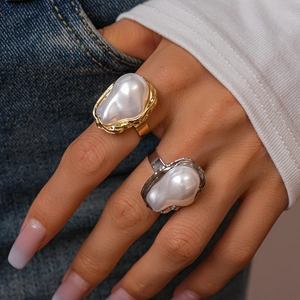 Detailed view of baroque pearl rings with irregular gold and silver textured bands