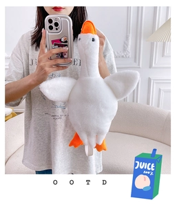 Mirror selfie showing soft white goose plush backpack with a long neck and orange beak