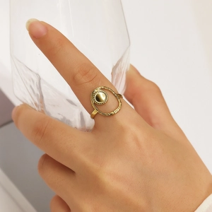 Minimalist gold four-leaf clover open ring with matte geometric texture on model's hand