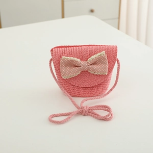 Close-up of pink straw crossbody bag for kids with polka dot bow and lace trim