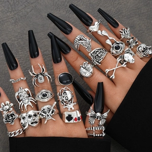 Gothic silver ring set featuring skull, spider, and heart motifs worn on model