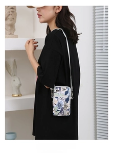 Detail of floral oxford crossbody phone bag with silver strap worn by a female model