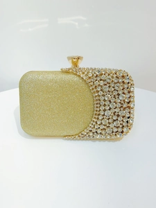 Close-up of gold evening clutch featuring sparkling rhinestones and glitter finish details