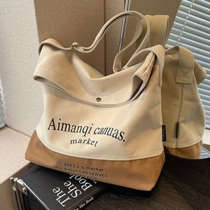 Dettaglio della borsa tote in tela beige e kaki con scritte stampate alla moda