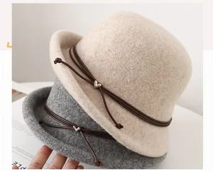 Close-up of wool felt cloche hats featuring leather bands and heart metal buckles