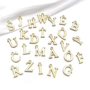 Makroaufnahme von 26 goldenen Legierungs-Initial-Anhängern für DIY-Schmuckherstellung
