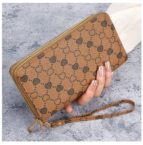 Detail showing the brown PU leather wristlet wallet with double golden zippers and heart pattern