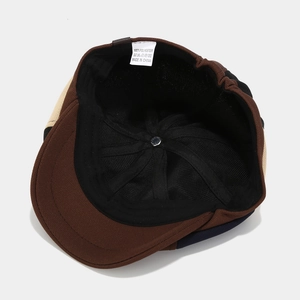 Detail view of the newsboy hat interior showing black lining and 100% polyester care label