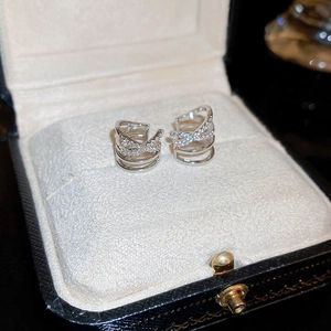 Macro shot of silver crisscross ear bone clips with zircon stones in a jewelry box