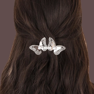 Silver hollow butterfly hair clip with clear rhinestones on model's brunette hair