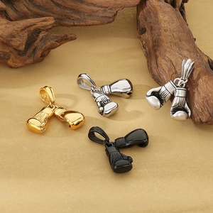 Pendentifs gants de boxe en or, argent, argent antique et noir sur un tissu rustique