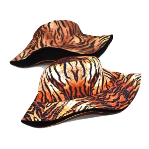 Reversible tiger print bucket hat with orange and black animal pattern and black lining