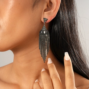Close-up of a model wearing a dark zircon fan-shaped tassel earring with silver needle studs