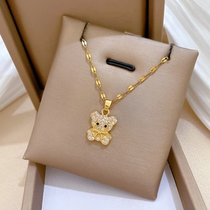 Close-up of golden bear pendant with sparkling cubic zirconia on a jewelry cushion