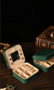 Macro detail of dark green velvet jewelry box showing mirror and removable dividers