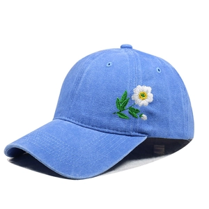 Close-up of light blue washed cotton baseball cap with delicate floral daisy embroidery