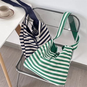Detail of striped canvas tote bags showing drawstring closure and wide shoulder straps