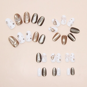 Detail of champagne cat-eye press-on nails with 3D bows, hearts, and pearl accents
