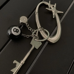 Detail of silver metal keychain set with star pendants, 8-ball charm and dice