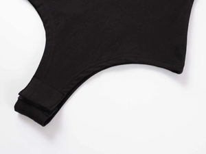 Detailed macro view of the snap button closure on black cotton knit bodysuit base