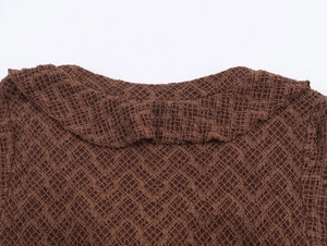 Detail of deep brown knit dress featuring V-neckline and diamond textured mesh fabric