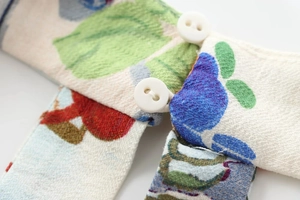 Close-up of vibrant floral print fabric texture with white round button details