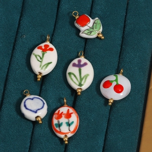 Detailed view of hand-painted floral and heart ceramic pendants with 18K gold plating