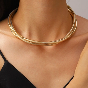 Close-up of a layered gold spring collar necklace worn by a model in a punk chic style
