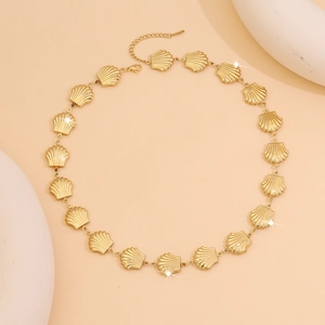 Detail of gold shell link necklace with adjustable clasp on beige aesthetic backdrop