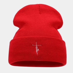 Close-up of white faith embroidery on a red ribbed knit beanie for men and women