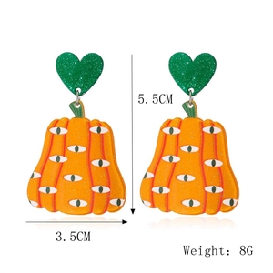 Macro shot of Halloween acrylic pumpkin earrings with green glitter hearts and multi-eye patterns