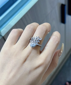 Close-up of a silver leaf ring with a pear-cut zircon worn on a woman's finger