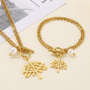 Detail of gold layered chain jewelry set with OT buckle, tree of life and pearl charms