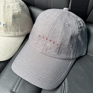 Dettaglio del cappellino in cotone con ricamo JOURNEY e trama in tessuto traspirante