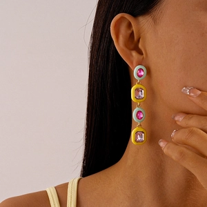 Detail of colorful geometric long earrings with candy-colored enamel and inlaid crystals