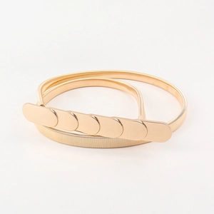 Close-up of gold elastic metal belt with oval link buckle on white background