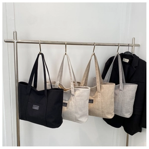 Detailed display of canvas tote bags in black, beige, khaki, and light grey colors