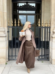 Street view of elegant brown long coat and high-waisted slit skirt with suede boots
