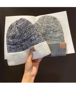Detailed view of winter knit beanies with thick fleece lining and embossed leather patch