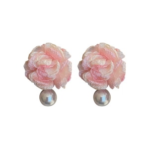 Elegant pink fabric flower earrings with faux pearls and silver pins on white background