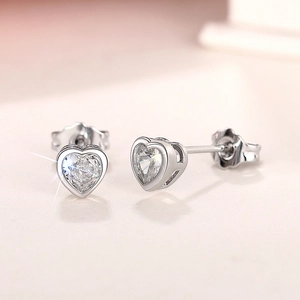 Detailed close-up of heart-shaped silver earrings with sparkling cubic zirconia stones
