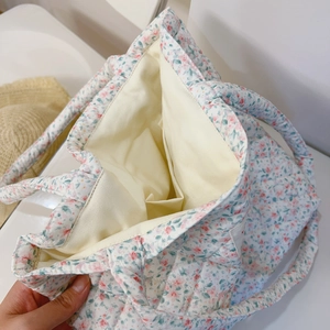 Détail du sac cabas en coton matelassé à fleurs montrant la poche intérieure