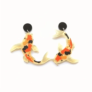 Asymmetric koi fish acrylic earrings in vibrant orange and black print on white background