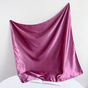 Detailed close-up showing the smooth, lustrous texture of the fuchsia satin square scarf