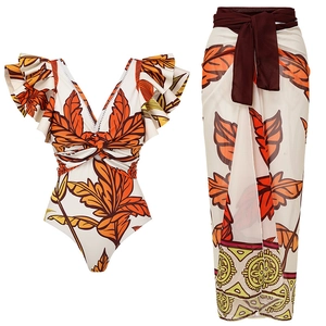One-shoulder tropical leaf print swimsuit set with matching wrap skirt for beach vacations