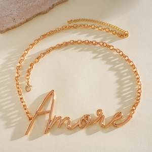 Detailansicht des eleganten goldenen Amore-Anhängers an einem modischen Metallkettengürtel.