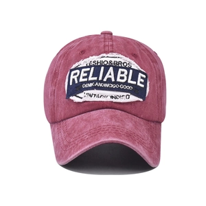 Close-up of vintage burgundy baseball cap featuring detailed RELIABLE patch embroidery