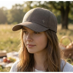 Close-up of side metal logo on dark brown baseball cap for men with twill texture