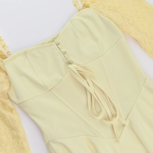 Detailed close-up of lace puff sleeves, corset lacing, and fabric buttons on yellow dress